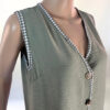 La imagen muestra un conjunto de dos piezas en color verde, compuesto por un chaleco sin mangas con botones decorativos en la parte frontal y una falda larga con abertura lateral. El diseño es elegante y versátil, ideal para ocasiones casuales o semi-formales. El tejido ligero y transpirable garantiza comodidad y un ajuste favorecedor.