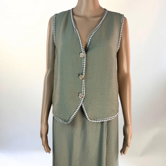 La imagen muestra un conjunto de dos piezas en color verde, compuesto por un chaleco sin mangas con botones decorativos en la parte frontal y una falda larga con abertura lateral. El diseño es elegante y versátil, ideal para ocasiones casuales o semi-formales. El tejido ligero y transpirable garantiza comodidad y un ajuste favorecedor.
